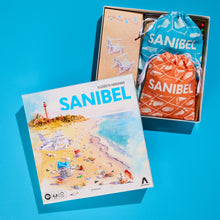 Board game box titled 'Sanibel' with a drawstring bag and packaging on a blue background
